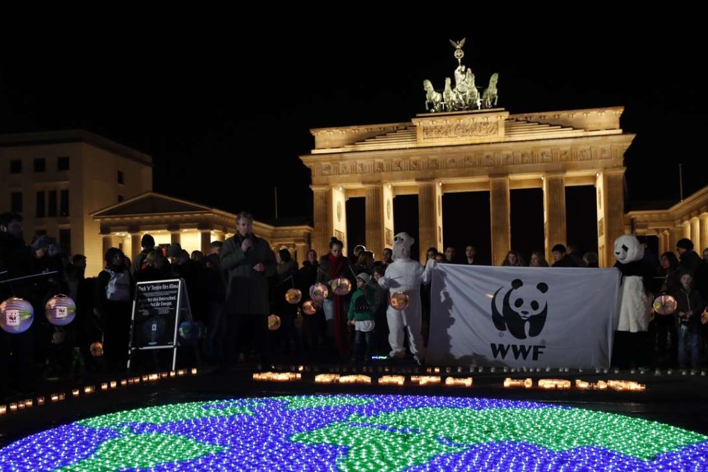 Candles are lit in front of the Brandenburg Gate before turning off its lights to commemorate Earth Hour in Berlin, Germany. Vladimir Putin just joined US President Donald Trump in expressing doubt over man-made climate change. Photo: EPA