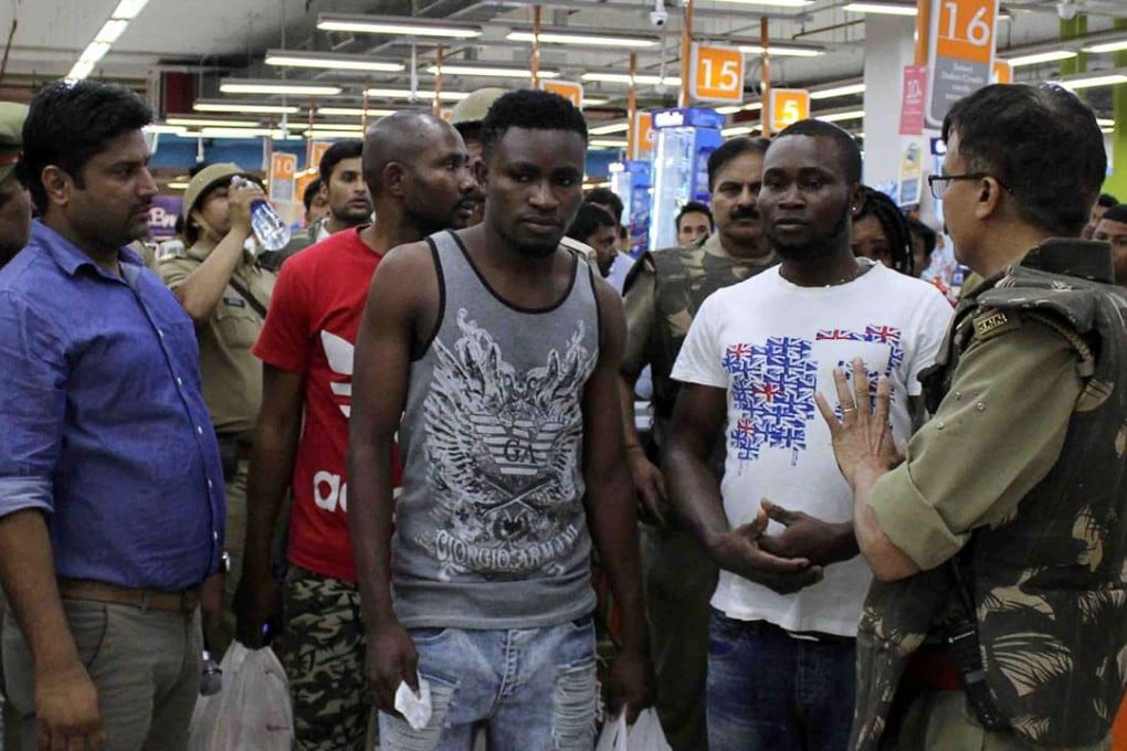 Indian police and onlookers surround African nationals at a shopping mall in Greater Noida on March 27. Hundreds of residents of an Indian city where a teenage boy died of a suspected drug overdose went on a violent rampage against Africans, using steel chairs to attack shoppers in a local mall. The riots broke out after New Delhi released five African students detained over the death. Photo: AFP