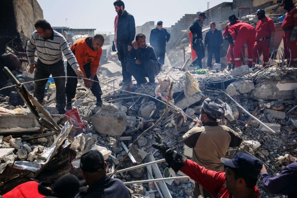 Locals help Iraqi civil defence force members recover bodies from a home destroyed in US-led bombing of the al-Jadida neighbourhood of Mosul on March 24, 2017. Photo: TNS