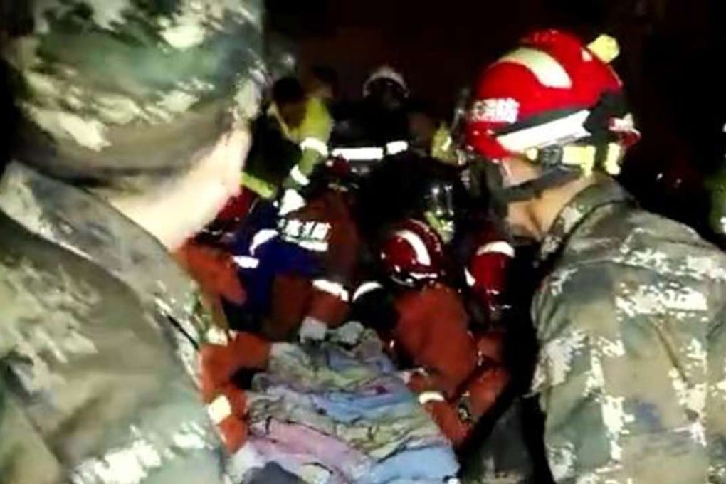 A video screenshot shows rescuers carrying the toddler to safety in Shandong province. Photo: Xinhua