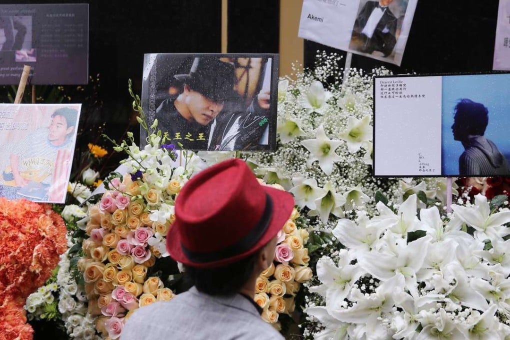 A fan of late Canto-pop singer Leslie Cheung looks at the wreaths and messages left in memory of the singer/actor outside the Mandarin Oriental Hong Kong hotel in Central last week. Photo: Sam Tsang