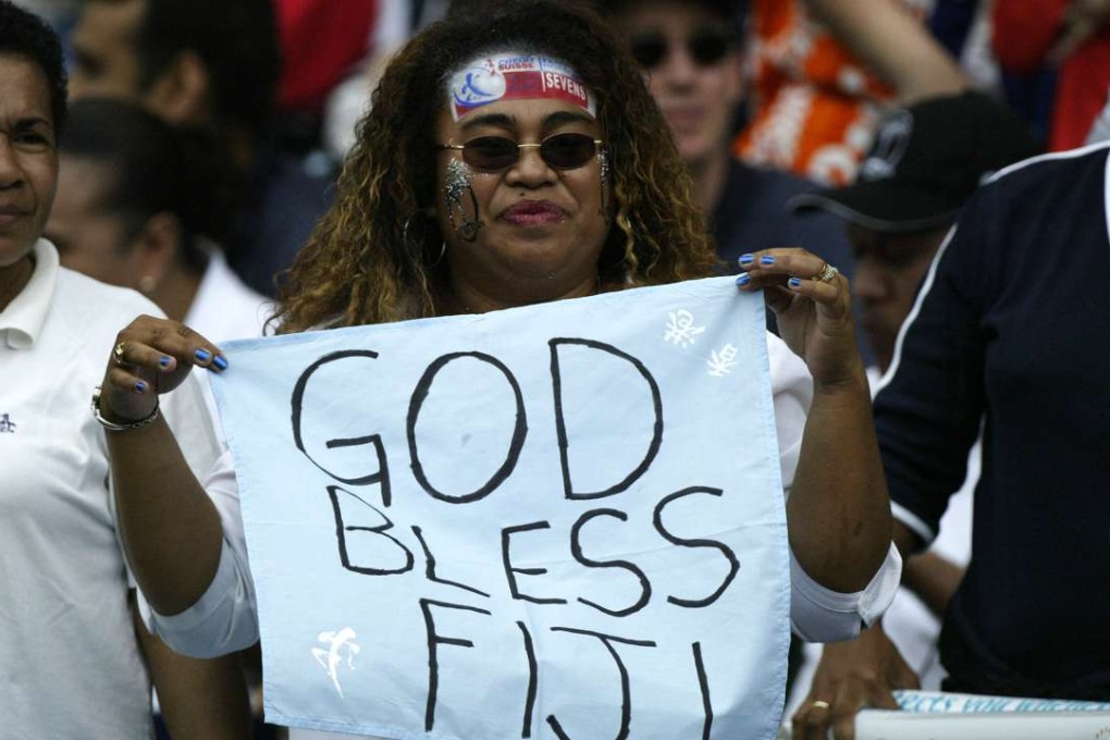 A Fijian rugby fan cheers for her favourite team during the Hong Kong Rugby Sevens tournament at Hong Kong Stadium. 30 March 2003