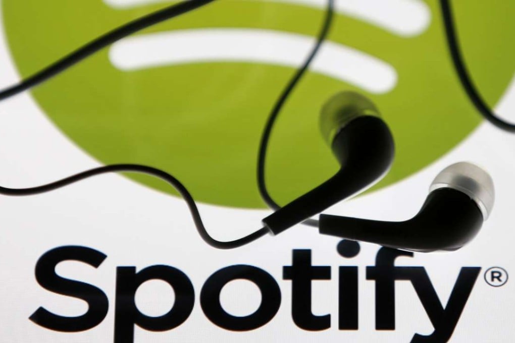 Earphones are seen on a tablet screen with a Spotify logo on it. Music streaming has made pop music faster although the attention span is shrinking. Photo: Reuters
