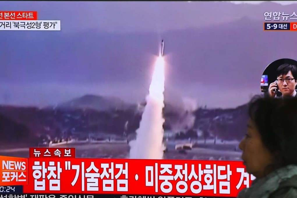 A woman walks past a television screen showing file footage of a North Korean missile launch, at a railway station in Seoul on April 5, 2017. The US said it will build a coalition to subdue Pyongyang, a close ally of China. Photo: AFP