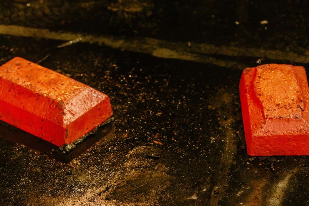 Two red-hot 28-kilogram gold bars cool after being removed from casting moulds in the foundry at the South Deep gold mine, operated by Gold Fields in Westonaria, South Africa. China’s Shandong Gold is said to be close to buying a 50 per cent stake in a Barrick gold mine. Photo: Bloomberg
