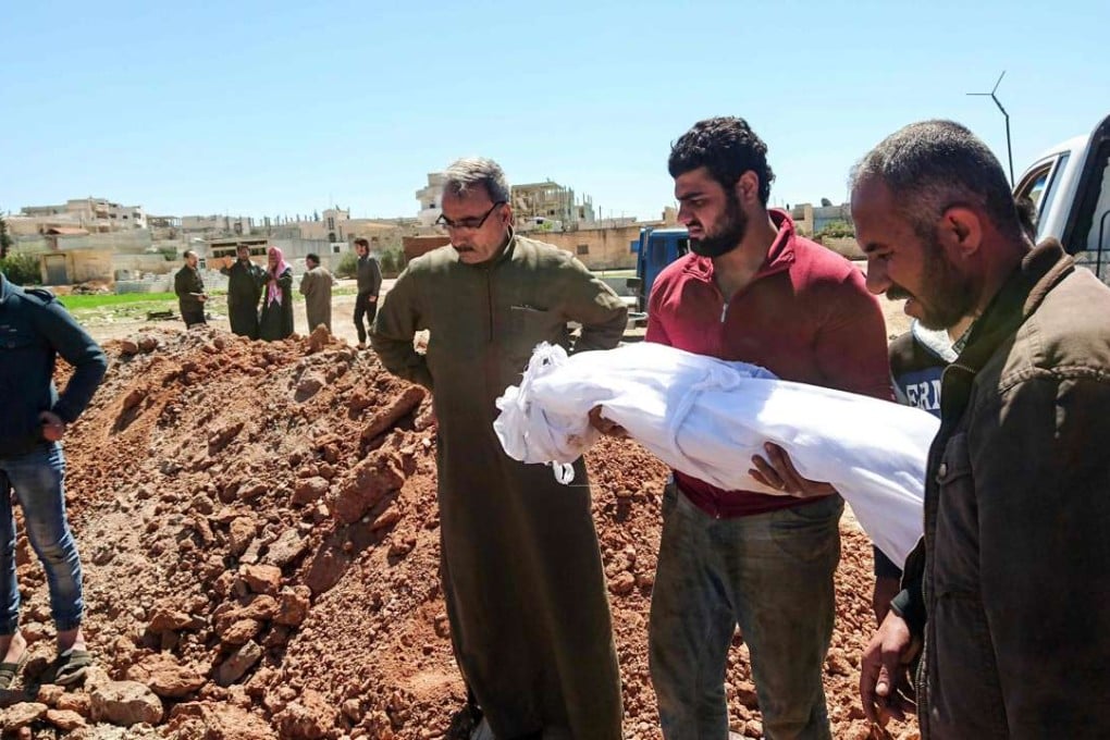 Syrians bury a child in a mass grave for victims of a toxic gas attack in Khan Sheikhun, a nearby rebel-held town in Syria’s northwestern Idlib province. Photo: AFP