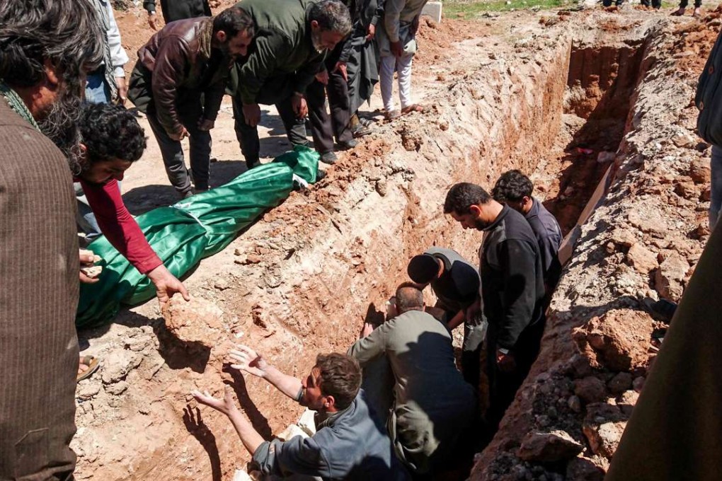 Syrians dig a grave to bury the bodies of victims of a toxic gas attack in Khan Sheikhun on Tuesday. Photo: AFP