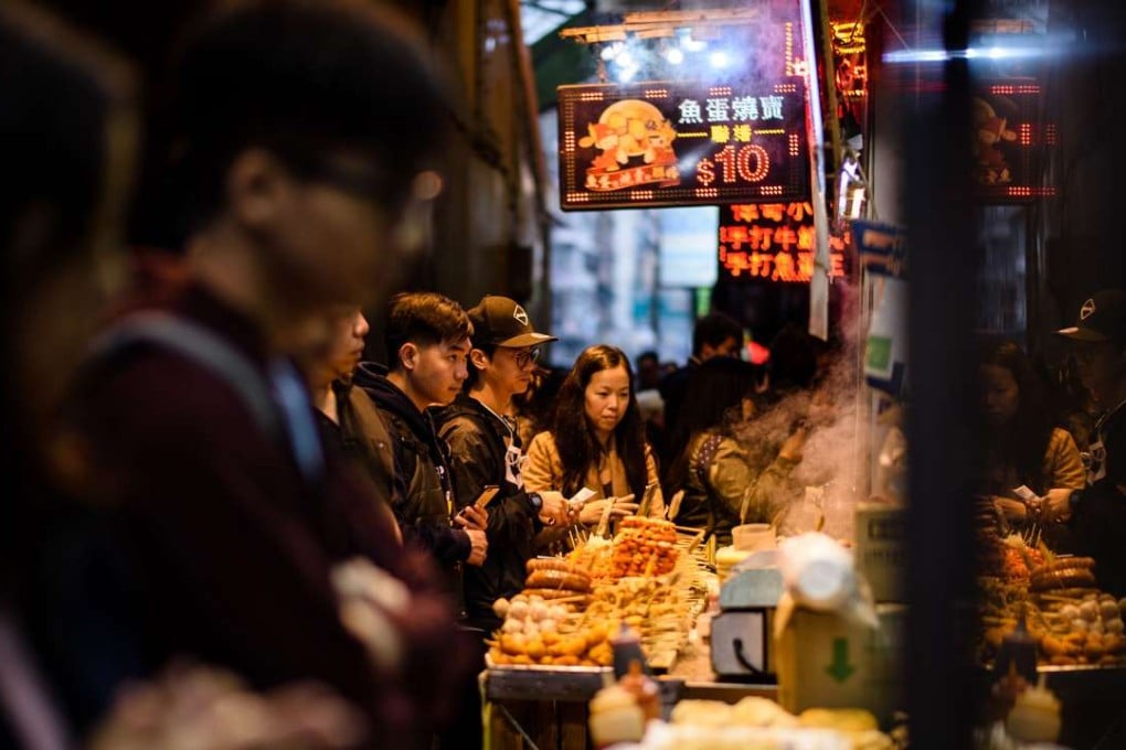 Customers queue to buy snacks being sold by food vendors. Photo: AFP Photo