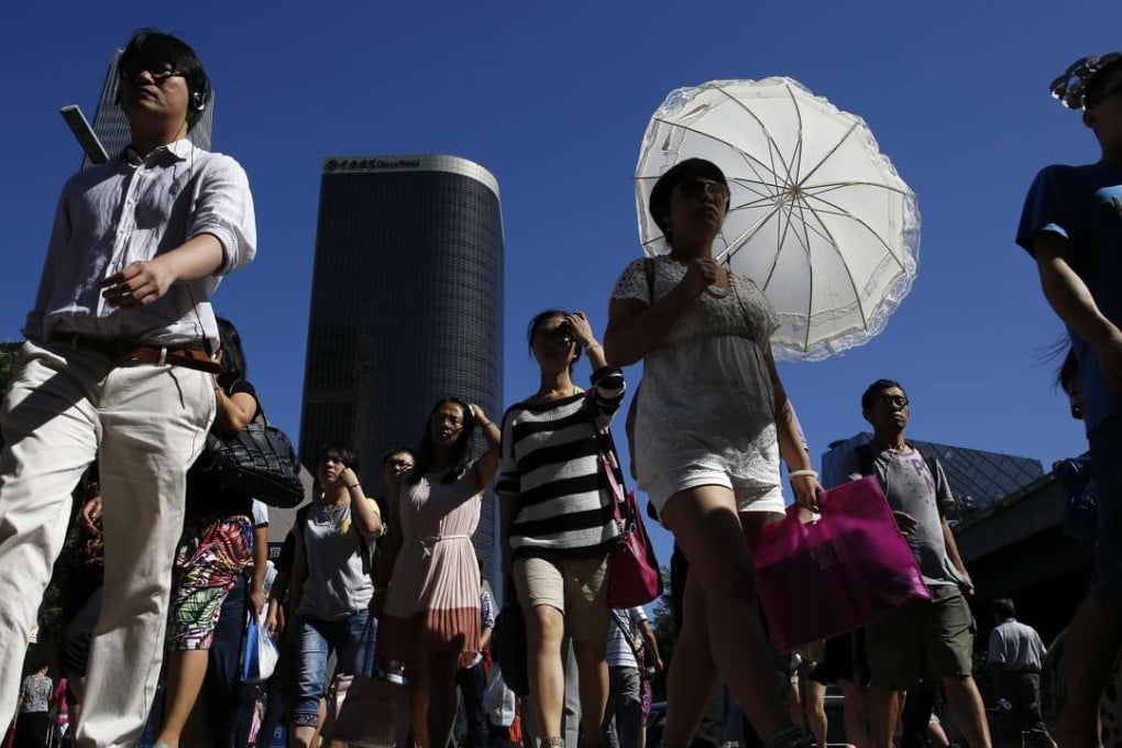 Pedestrians cross the road in the central business district of Beijing. Big rewards are on offer in the capital for information about foreign spies. Photo: EPA