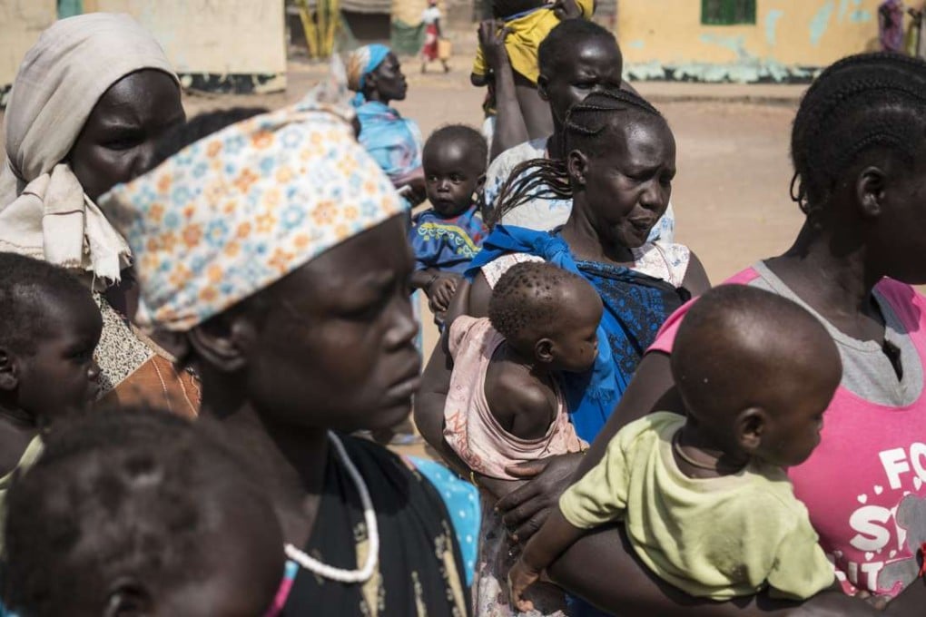 Mothers hold their children as they wait to have them screened for malnutrition at a UNICEF-supported Outpatient Therapeutic Programme in Aweil, South Sudan. Some 16 people were killed in ethnically-inspired attacks in South Sudan. Photo: UNICEF via AP