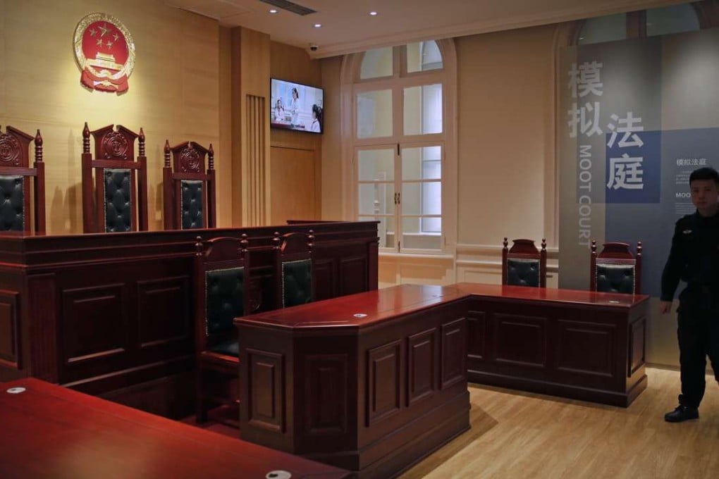 A security guard walks into a mock courtroom on display at the China Court Museum in Beijing. In mainland China, witness attendance at court is, historically, very low, particularly in criminal cases. Photo: AP