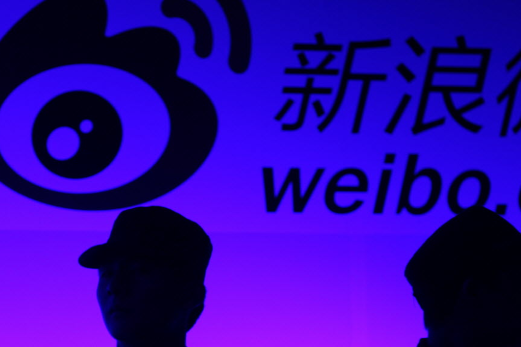 Two security guards stand in front of a big light-box of Sina's weibo.com, China's biggest microblog site. Photo: Simon Song