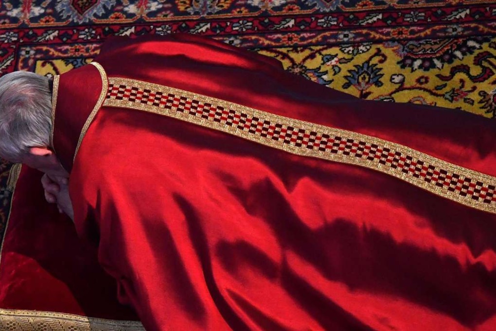 Pope Francis lies on the ground to pray during a mass for the Celebration of the Lord's Passion on Good Friday at St Peter's basilica, in Vatican City. Photo: EPA