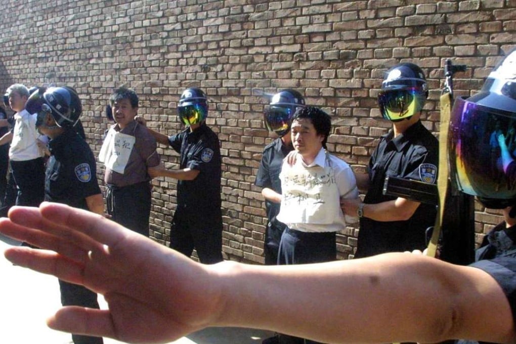In this file photo from June 2004, a policeman signals to reporters to keep their distance as four drug traffickers are prepared for execution in Xian in Shaanxi province. Photo: AP