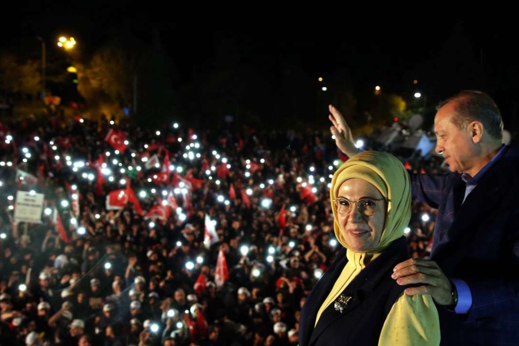 A handout photo made available by the Turkish President Press office shows President Recep Tayyip Erdogan and wife Emine waving to supporters during a rally in front of the presidential residence in Istanbul on Sunday. Photo: EPA