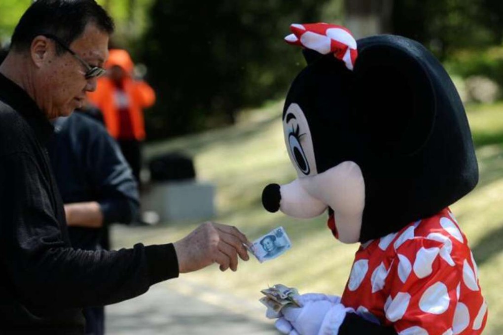 Ying Peizhi poses with tourists in a Minnie Mouse costume to earn extra money. Photo: Handout