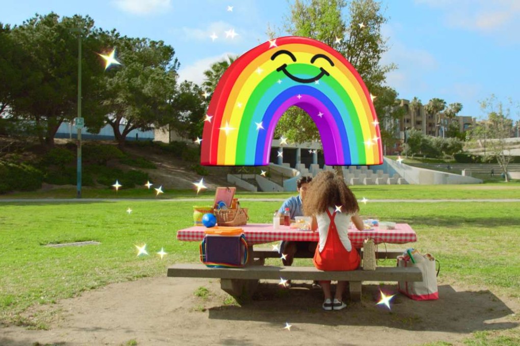 Snapchat users can drag, drop and resize a smiling rainbow as they capture a scene with their front-facing camera.