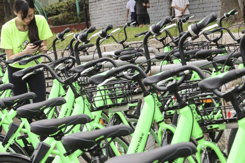 A Gobee.bike staff member demonstrates the use of QR code scanning on the mobile phone to unlock the service. Photo: Felix Wong