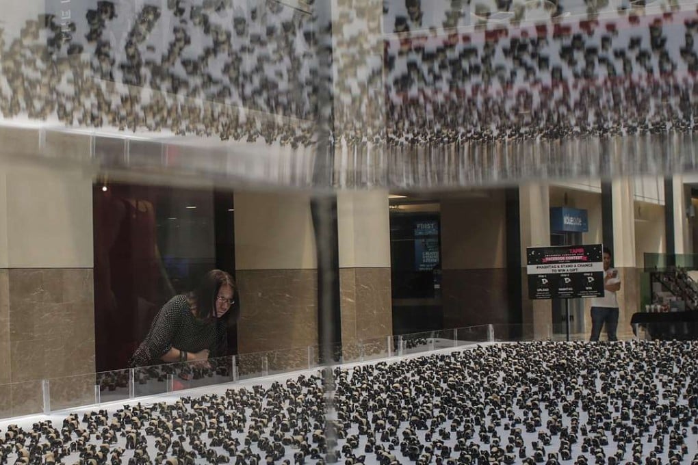 A woman looks at some of the 3,000 Malayan tapir clay figurines made by school children across the Malaysia during the Malayan Tapir Awareness Campaign at Kuala Lumpur. The country recently passed the Sexual Offences against Children Bill, but it does not criminalise child marriage. Photo: EPA
