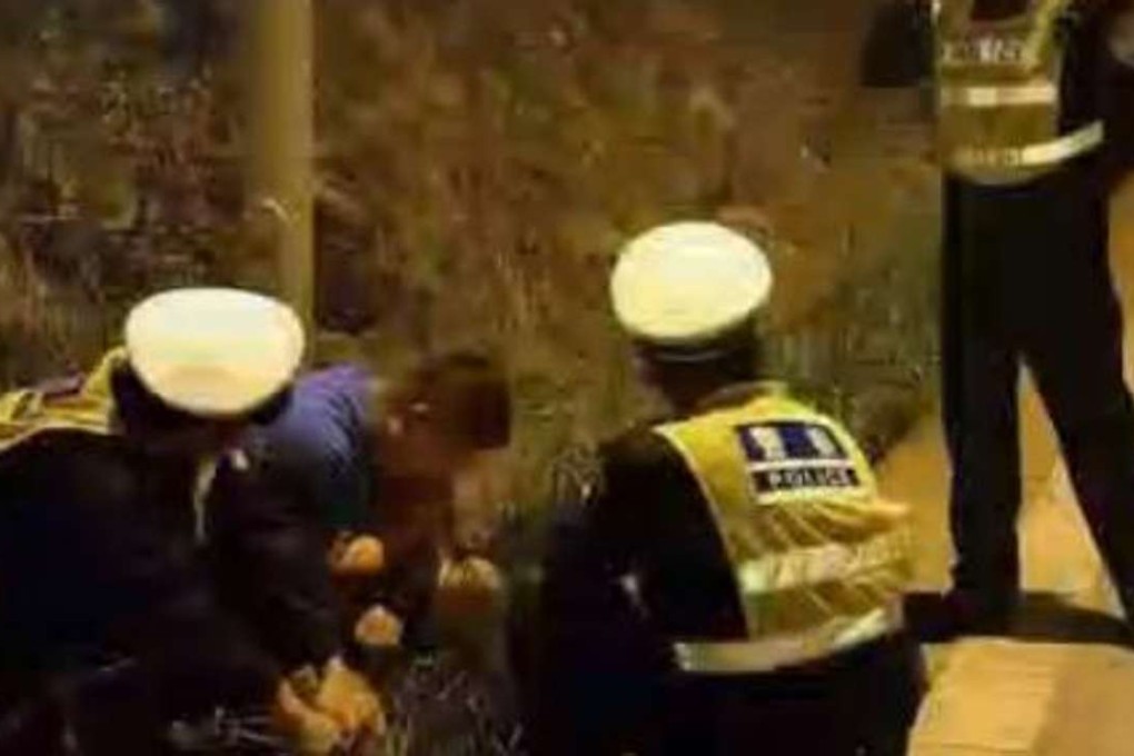 The driver surrounded by police officers at the side of the road. Photo: Handout