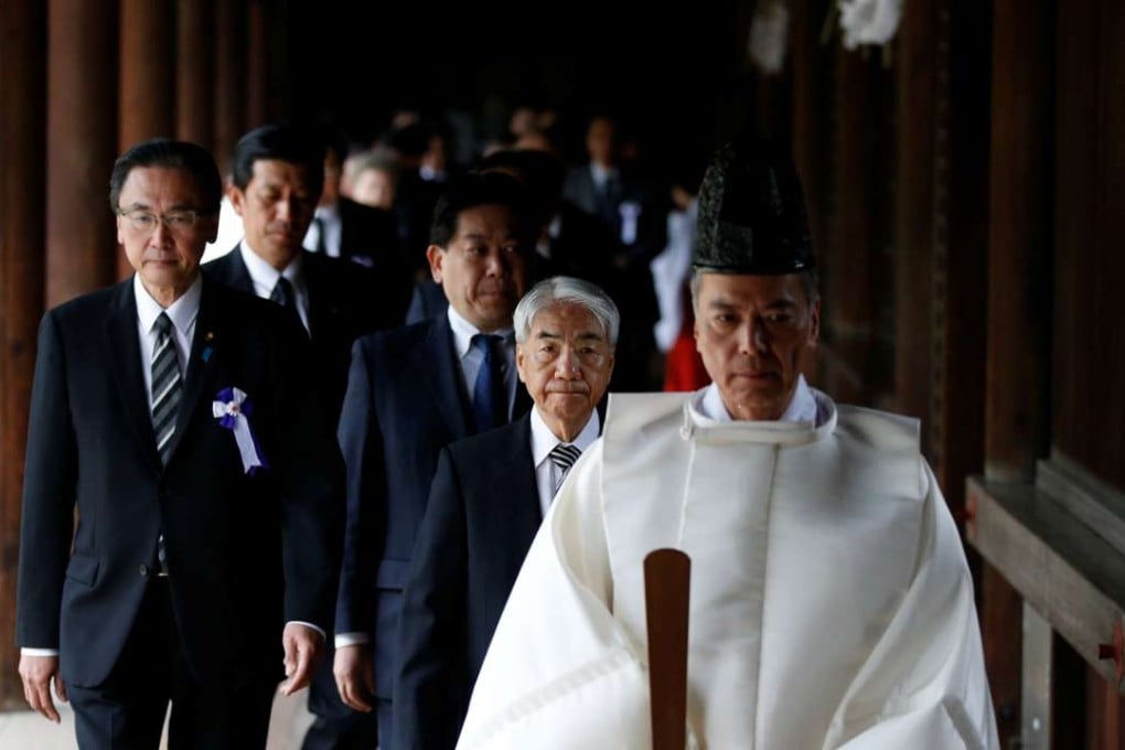 A group of lawmakers are led by a Shinto priest as they visit Yasukuni Shrine in Tokyo. Photo: Reuters