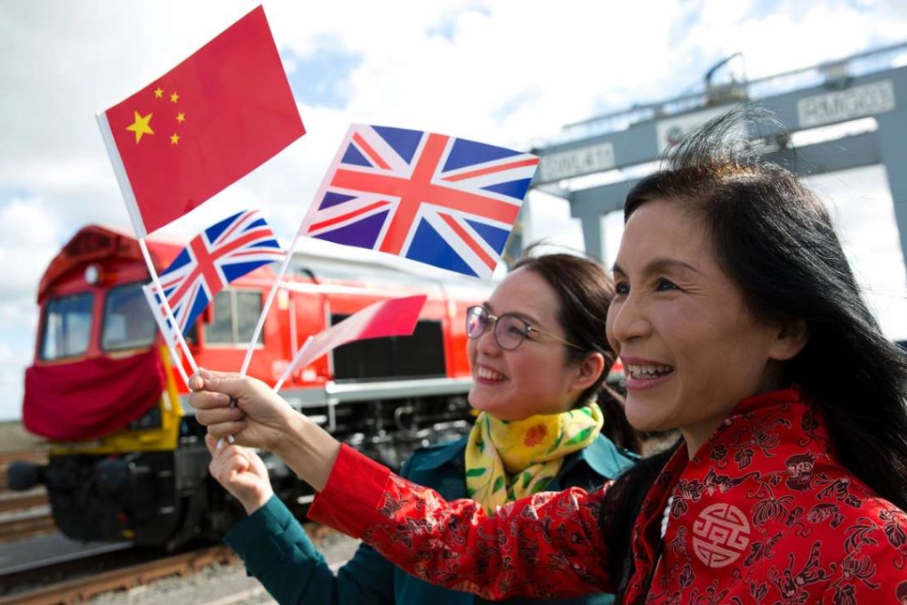 People wave Chinese and Union flags as they pose for photographs during the departure of a freight train transporting containers laden with goods from the UK en route to Yiwu in the eastern Chinese province of Zhejiang. Photo: AFP