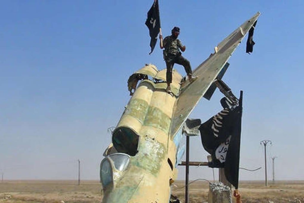 A file picture of Islamic State fighters next to a destroyed Syrian air force jet. Photo: Associated Press