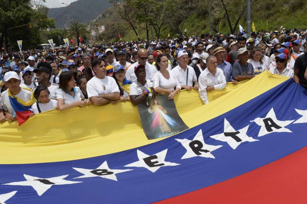 Venezuelan opposition activists march to the Catholic Church's episcopal seat in a quiet show of condemnation of the government of President NIcolas Maduro, in Caracas, on April 22, 2017. Venezuelans gathered Saturday for "silent marches" against President Maduro, wearing white after three weeks of violent unrest left 20 people dead. Photo: AFP
