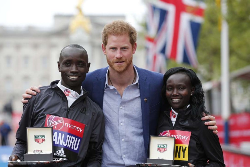 Prince Harry poses with the winner of the men's elite race Kenya's Daniel Wanjiru and the winner of the women's elite race Kenya's Mary Jepkosgei Keitany. Photo: Reuters