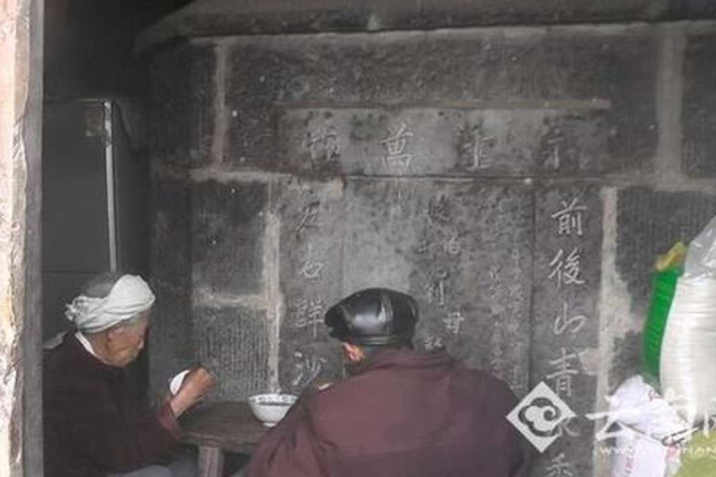 The couple eating next to one of the tombs. Photo: Yunnan.cn