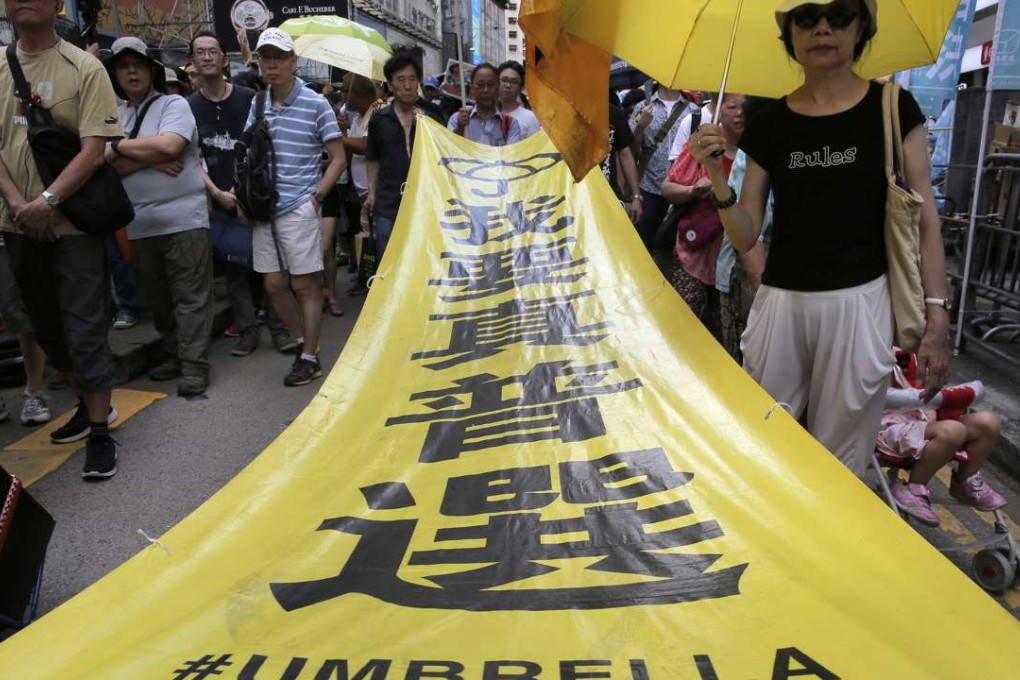 Demonstrators taking part in Hong Kong’s annual pro-democracy march carry a banner saying “I want genuine universal suffrage”, above the hashtag “Umbrella Revolution”, last July 1. Photo: AP