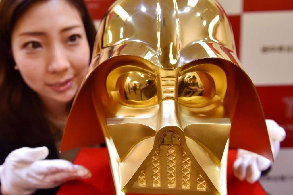 An employee of Japan's jeweller Tanaka Kikinzoku Jewellery displays a pure gold life size mask of Darth Vader. Photo: AFP