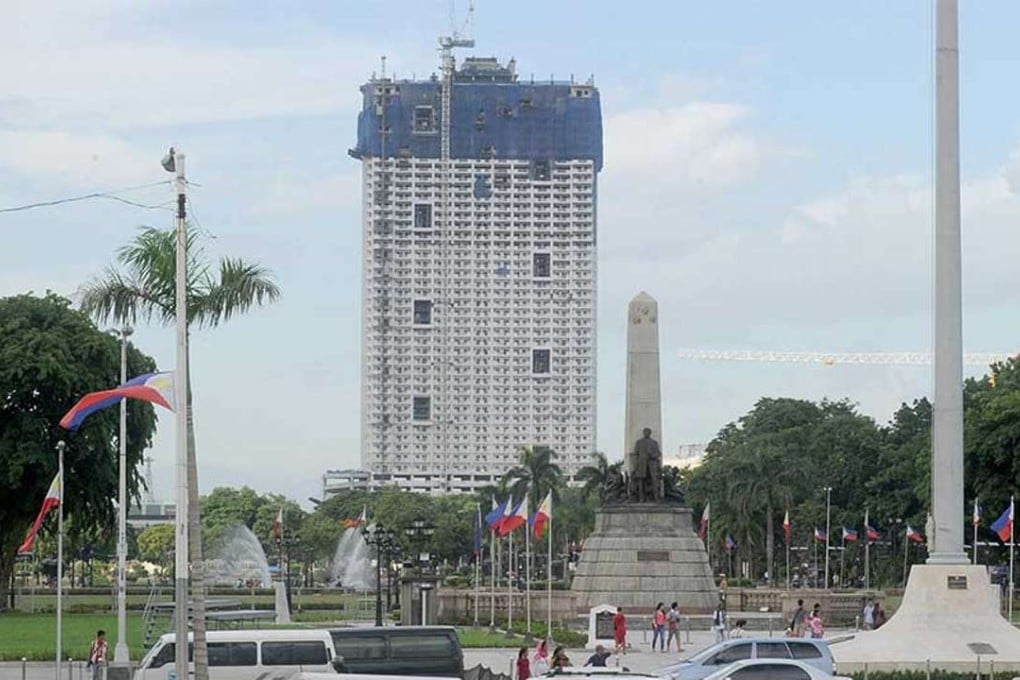 The 49-storey Torre de Manila high-rise condominium looms in the background from the Jose Rizal tomb and monument at Luneta Park in Manila. Photo: AFP