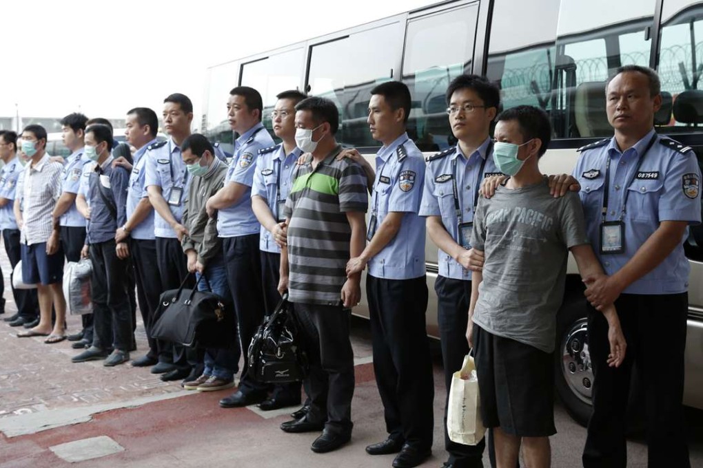 Six fugitives involved in economic crimes are taken back under escort from Indonesia at the Beijing airport in 2015. Photo: Xinhua
