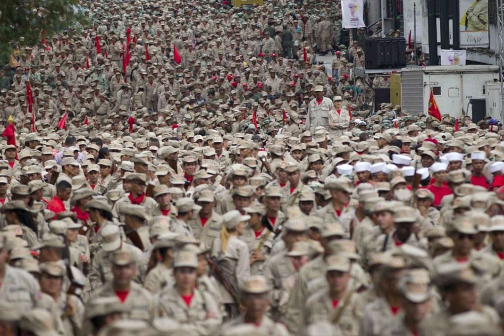 Members of the Bolivarian Militia march during their seventh anniversary celebration, in front of the Miraflores presidential palace in Caracas, Venezuela, on April 17, 2017. President NIcolas Maduro has pledged to arm the massive paramilitary group. Photo: AP