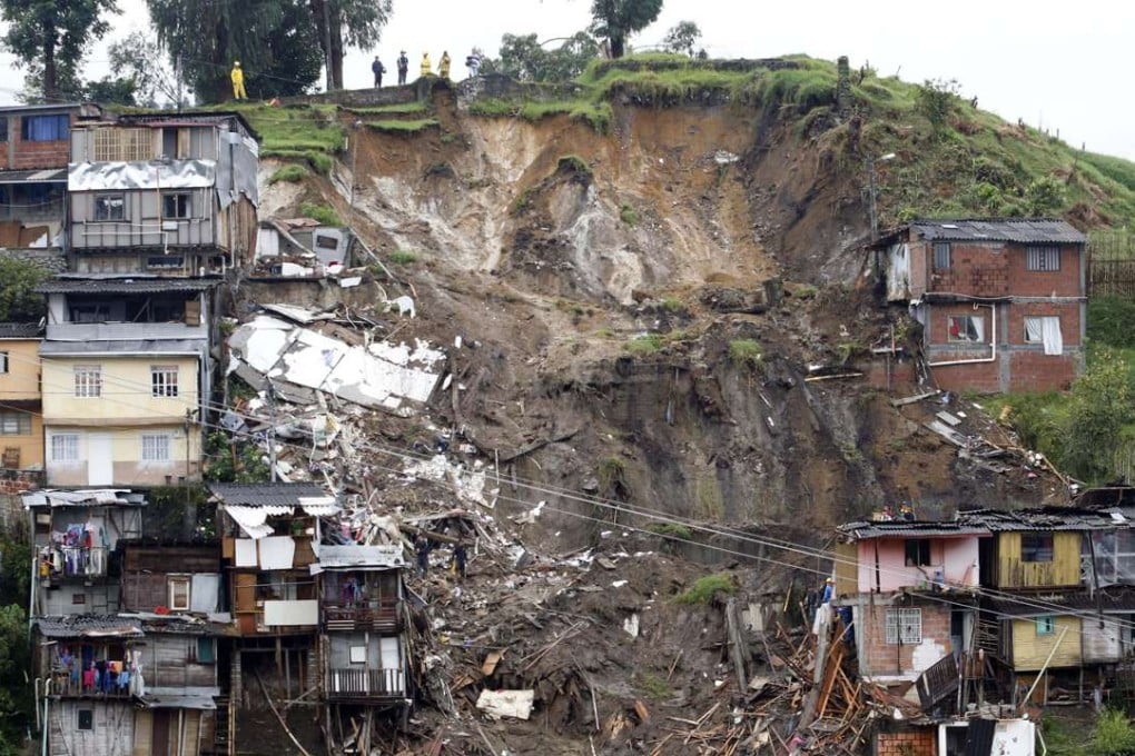 Rescue workers survey an area where a landslide destroyed several homes in Manizales, Caldas, Colombia. At least eleven people were killed and 20 are missing after heavy rains caused landslides in this mountainous region of Colombia, a country which is vulnerable to climate change. Photo: EPA