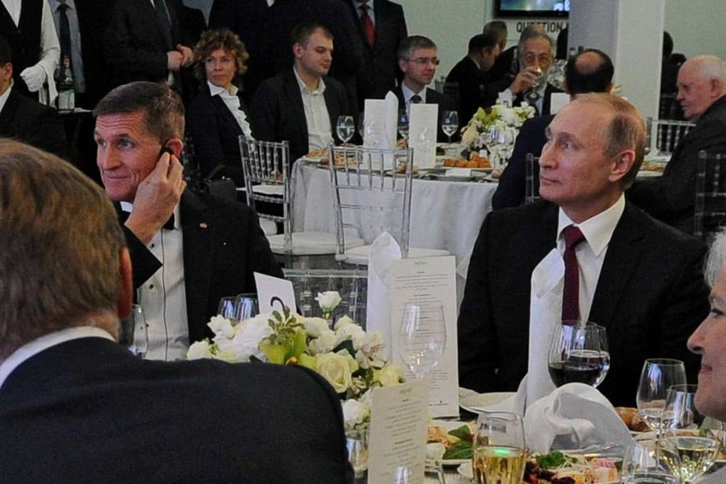 Russian President Vladimir Putin (rght) sits next to retired US Army Lieutenant General Michael Flynn (left) as they attend an exhibition marking the 10th anniversary of Russia Today television news channel in Moscow, Russia, December 10, 2015. Photo: Reuters