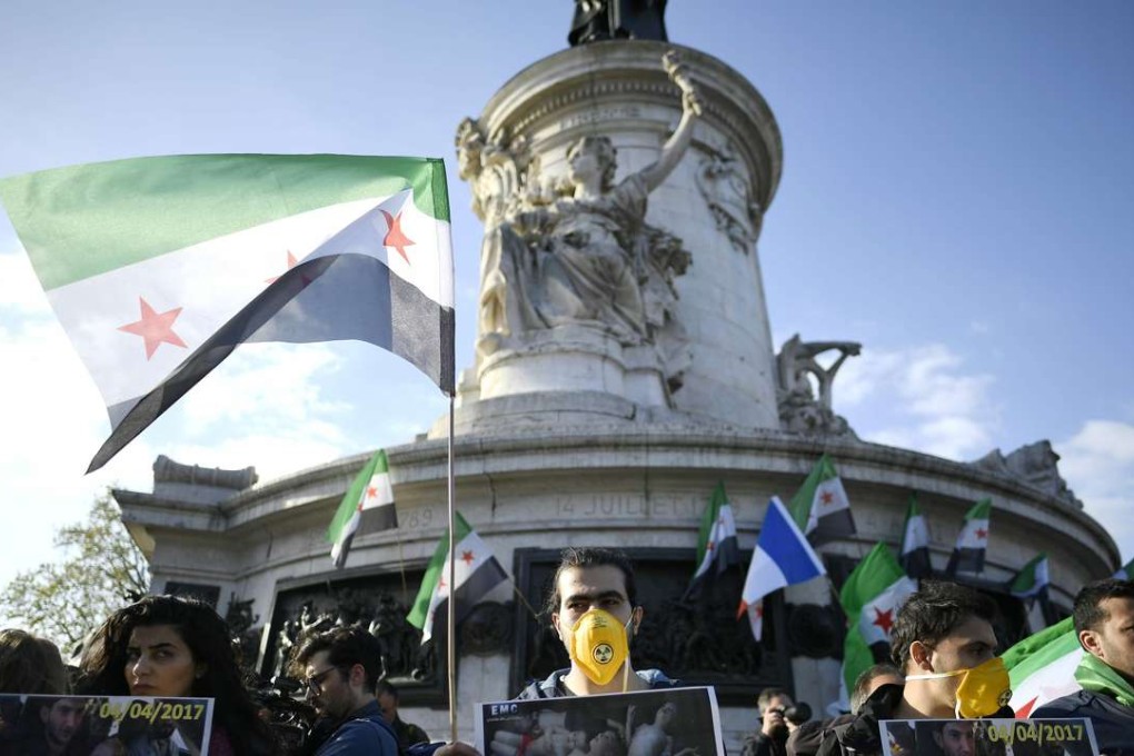 Protesters hold pictures and Syria's former independence flags during a demonstration to protest against chemical attacks in Syria on the Place de la Republique, in Paris. Photo: AFP