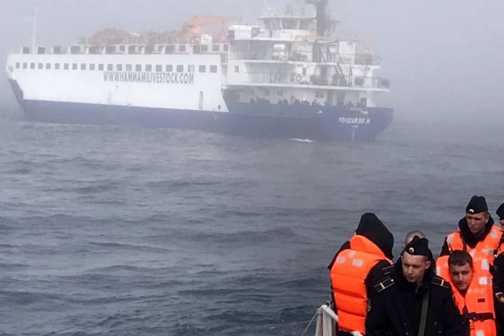 Rescued Russian sailors are seen on the deck of a Turkish coast guard vessel after their spy ship collided with a livestock freighter, seen in the background, and sank off the Bosphorus strait on Thursday. Photo: EPA