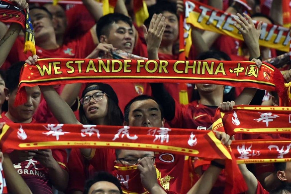 Fans of China's Guangzhou Evergrande hold up scarves in support of their team against Eastern, though their English spelling is not the best. Photo: AFP PHOTO / Anthony WALLACE