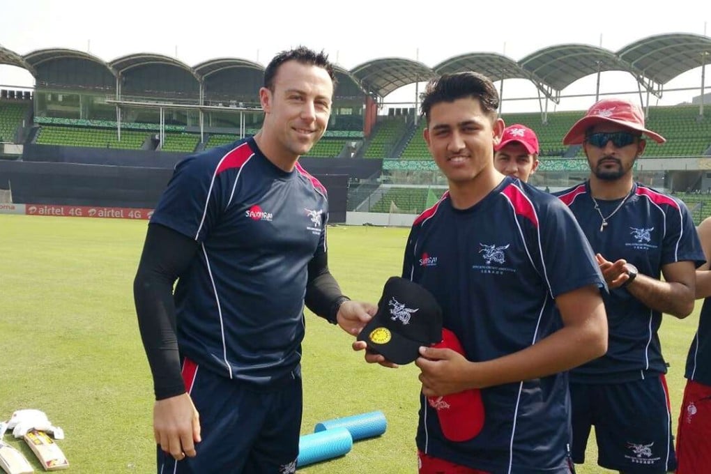Mark Wright presents Hong Kong player Tanveer Ahmed with his T20 International debut cap at the Asia Cup in 2016. Photo: Cricket Hong Kong
