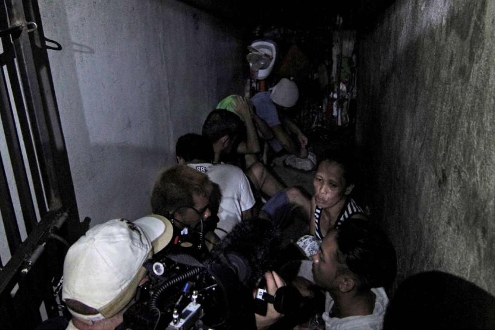 This photo taken April 27, 2017 shows people allegedly kept inside a hidden room at the Drug Enforcement Unit of the Manila Police Department's Police Station 1 in the Tondo area of Manila. Human rights workers found a dozen people on April 27 stuffed inside a dark, closet-sized jail cell hidden behind a book shelf in a Philippine police station. The rights officials, acting on a tip, made the surprise inspection on the police station and were calling out for any detainees to come forward. / AFP PHOTO / Vincent GO