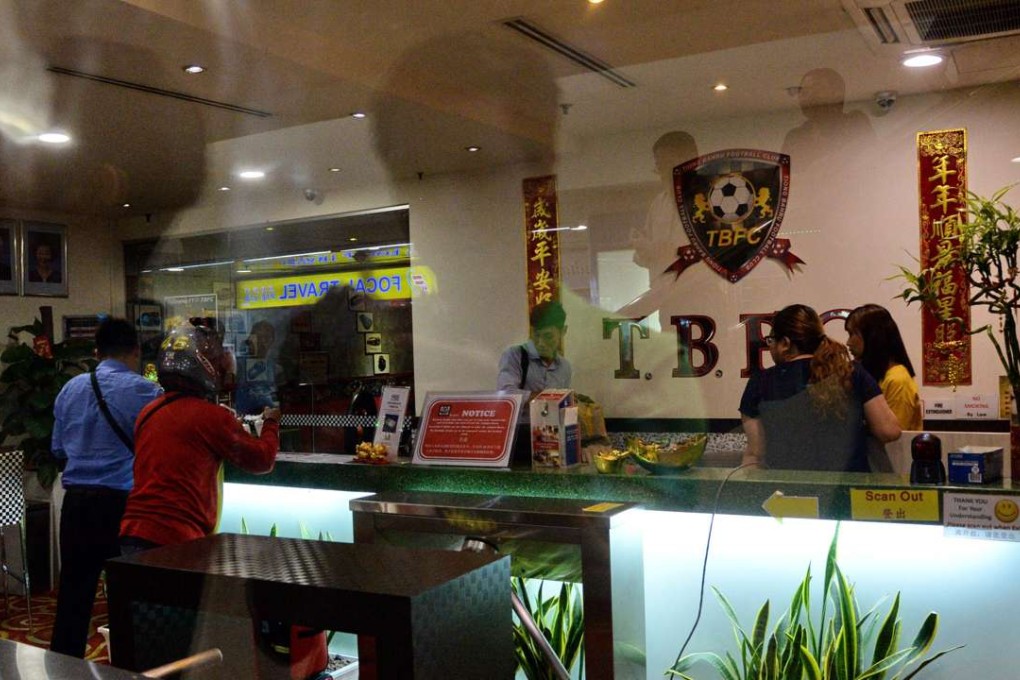 Investigators go inside the Tiong Bahru Football Club as part of a raid on the offices of the city state's football governing body, which is in the throes of a leadership struggle ahead of a Fifa-ordered election. Photo: AFP