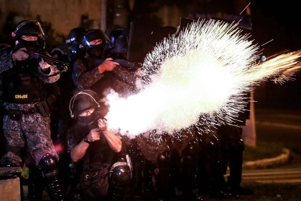 Riot police fire their weapons during a protest in Sao Paulo, Brazil. Photo: EPA