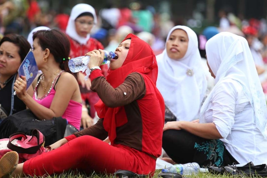 Indonesian maids replenish themselves during hot weather at Victoria Park, Causeway Bay. Hong Kong is home to some 350,000 foreign domestic workers, with 156,000 of them coming from Indonesia. Photo: Nora Tam