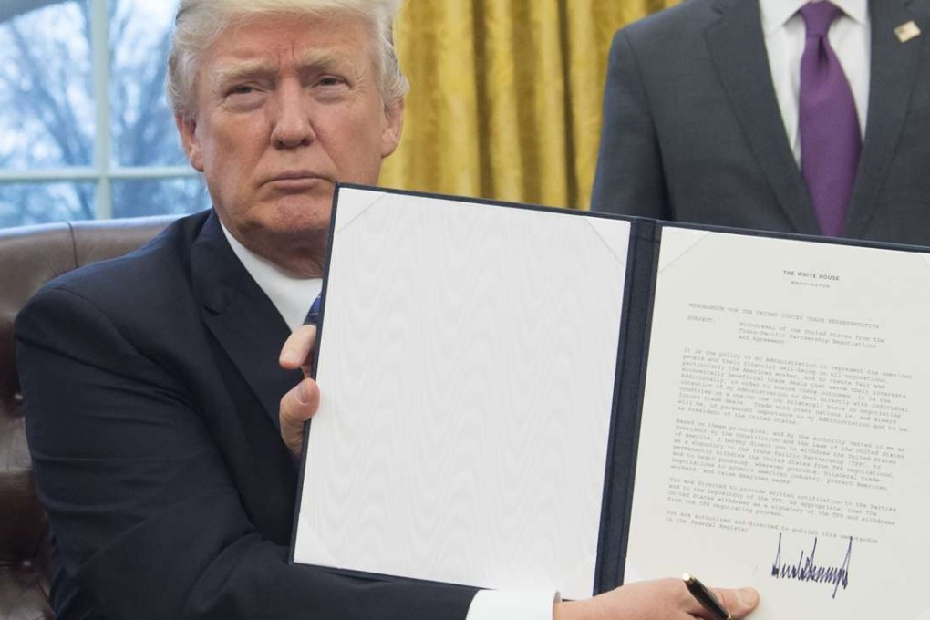 US President Donald Trump holds up an executive order withdrawing the US from the Trans-Pacific Partnership after signing it in the oval office of the White House on January 23. Photo: AFP
