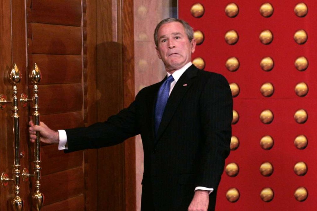 George W. Bush jokingly makes a face as he tries to open a locked door as he leaves a press conference in Beijing in 2005. File photo: AP