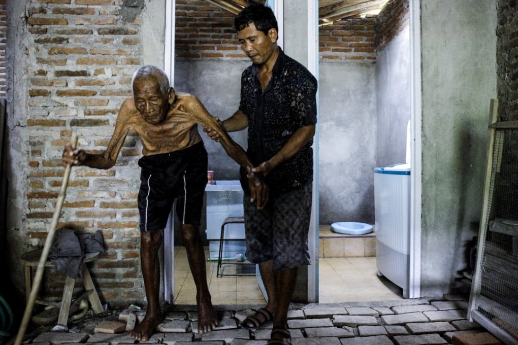 Sodimejo, also called as 'Mbah Gotho' is assisted by his grandson Suryanto in Sragen, Central Java. Mbah Gotho was claimed to be the world's oldest man with documentation that stated that he was born in 1870. Photo: EPA