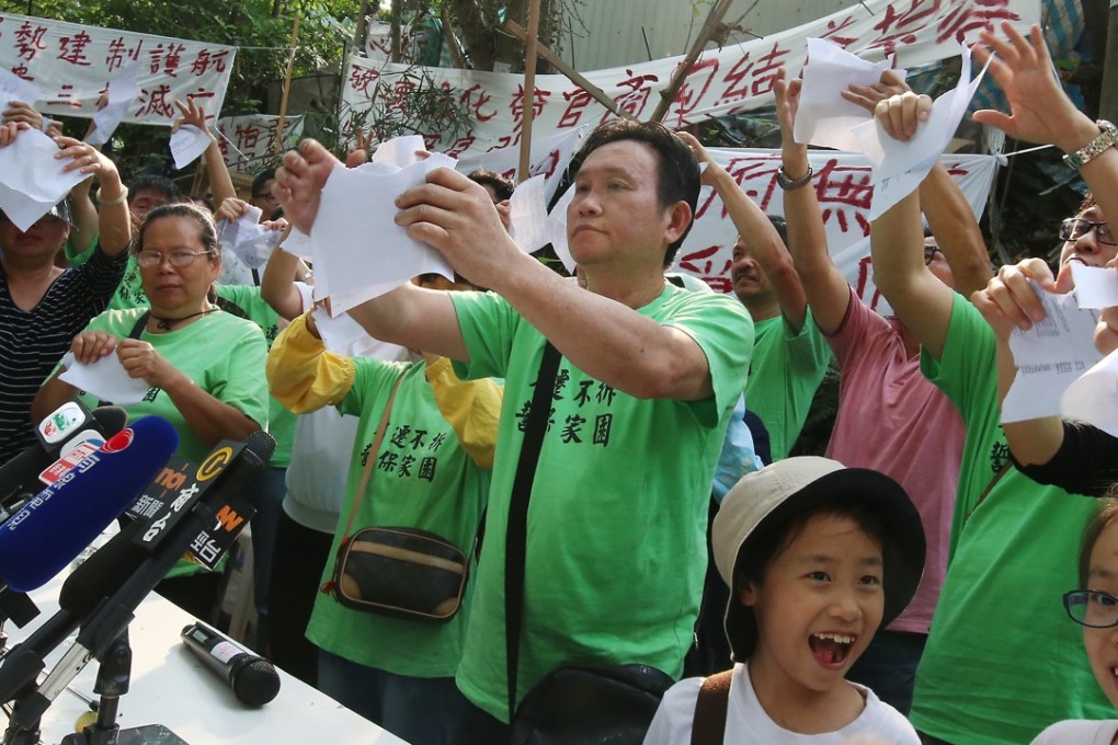 Residents from Wang Chau tearing up government notices about the land plan. Photo: David Wong