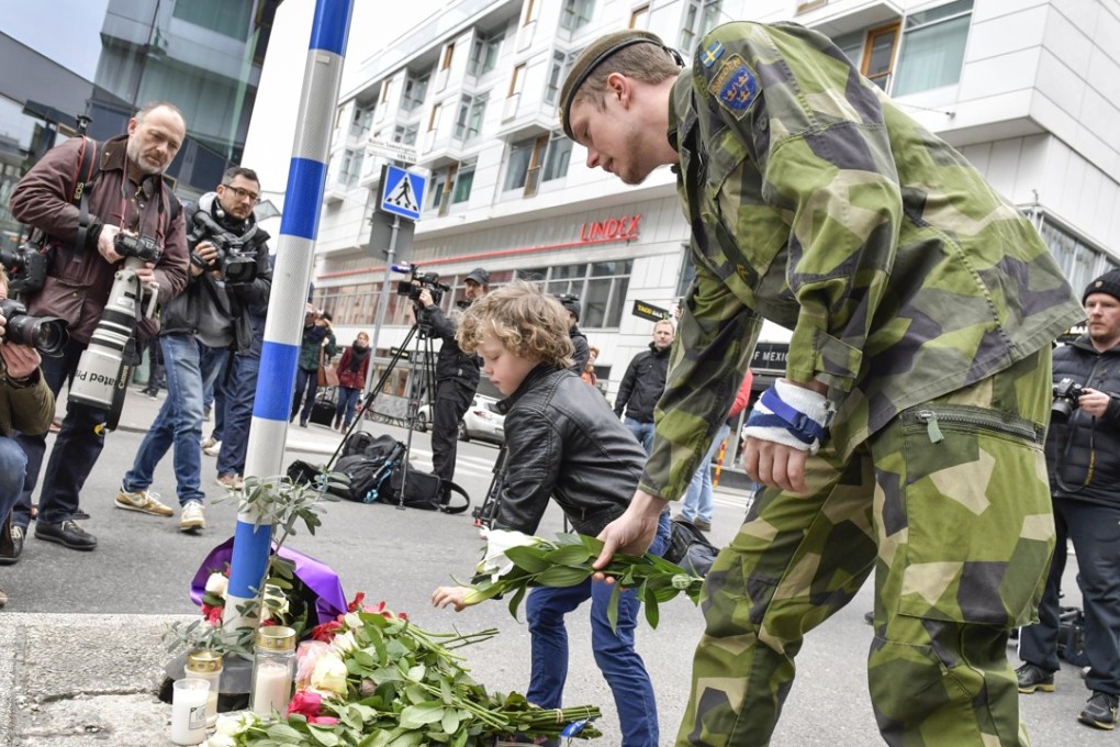 People lay flowers in central Stockholm, Sweden, the morning after a hijacked truck ploughed into pedestrians, killing four. Photo: EPA